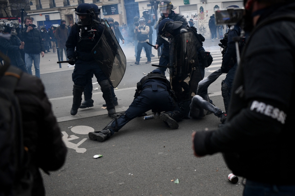 French anti-riot police forces detain a protestor during a demonstration after the government pushed a pensions reform through parliament without a vote, in Paris on March 28, 2023. (Photo by Christophe Archambault / AFP)