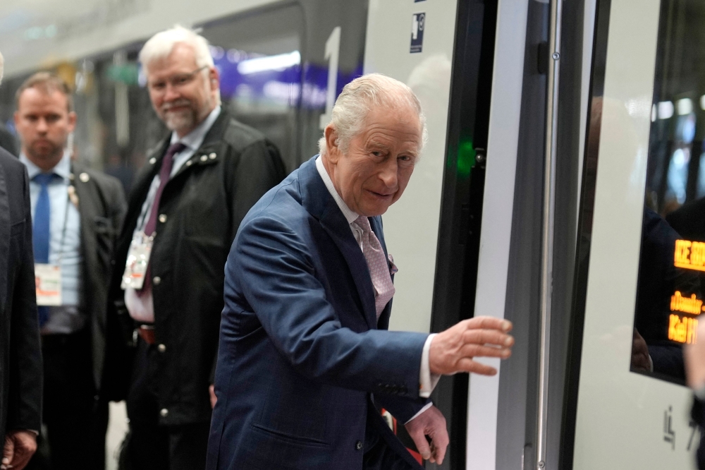 Britain's King Charles III boards a train on a way to Hamburg at the main train station in Berlin, on March 31, 2023. Photo by Markus Schreiber / POOL / AFP