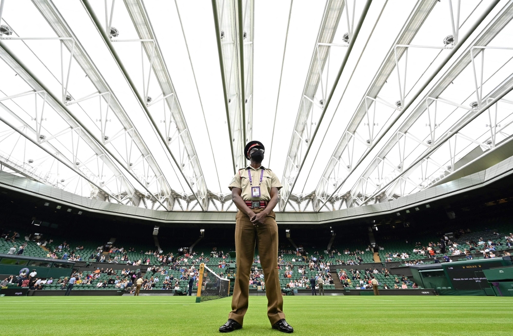 In this file photo taken on June 28, 2021, a member of Britain's armed forces stands on duty ahead of a men's singles first-round match, under the closed roof on Centre Court, on the first day of the 2021 Wimbledon Championships at The All England Tennis Club in Wimbledon, south-west London. (Photo by Glyn Kirk / AFP) 