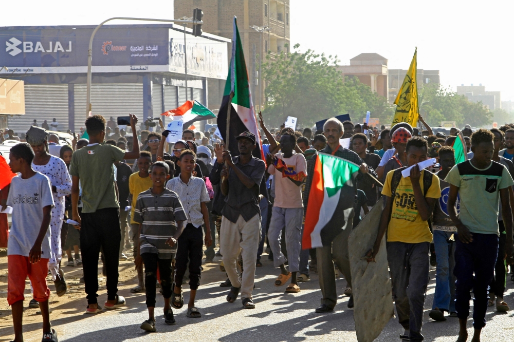 Sudanese protesters take part in a demonstration in southern Khartoum on April 6, 2023 marking a key anniversary in the decades-old struggle against military rule with new protests against the general. (Photo by Ebrahim Hamid / AFP)