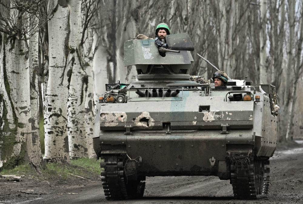 Ukrainian servicemen ride on Dutch YPR-765 armoured personnel carrier (APC) on a road near Bakhmut, Donetsk region, on April 6, 2023, amid the Russian invasion of Ukraine. (Photo by Genya Savilov / AFP)