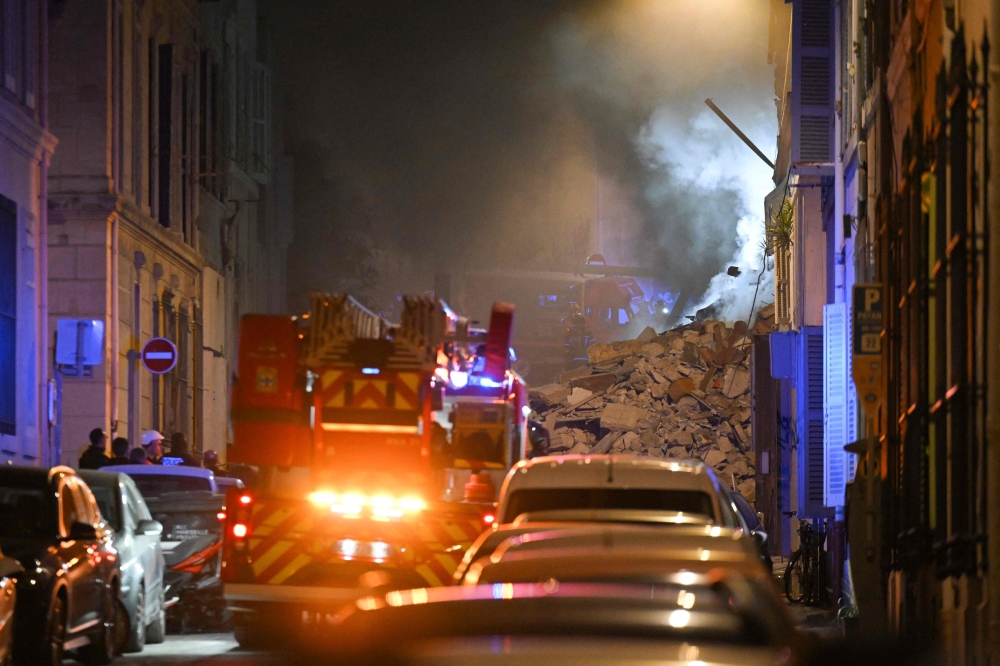 Rescue vehicles gather at the scene where a building collapsed in the southern French port city of Marseille early on April 9, 2023. (Photo by Nicolas Tucat / AFP)