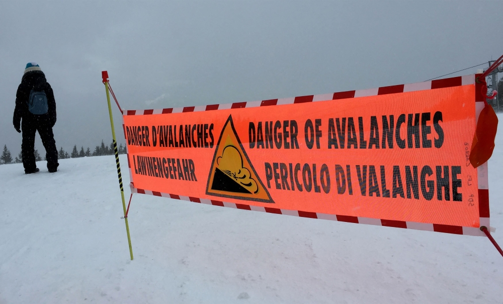 This file photo taken on February 13, 2016, shows a banner indicating a high risk of avalanche placed at the top of the slopes in the Haute Savoie resort of Les Carroz d'Araches. (Photo by Denis Charlet / AFP)