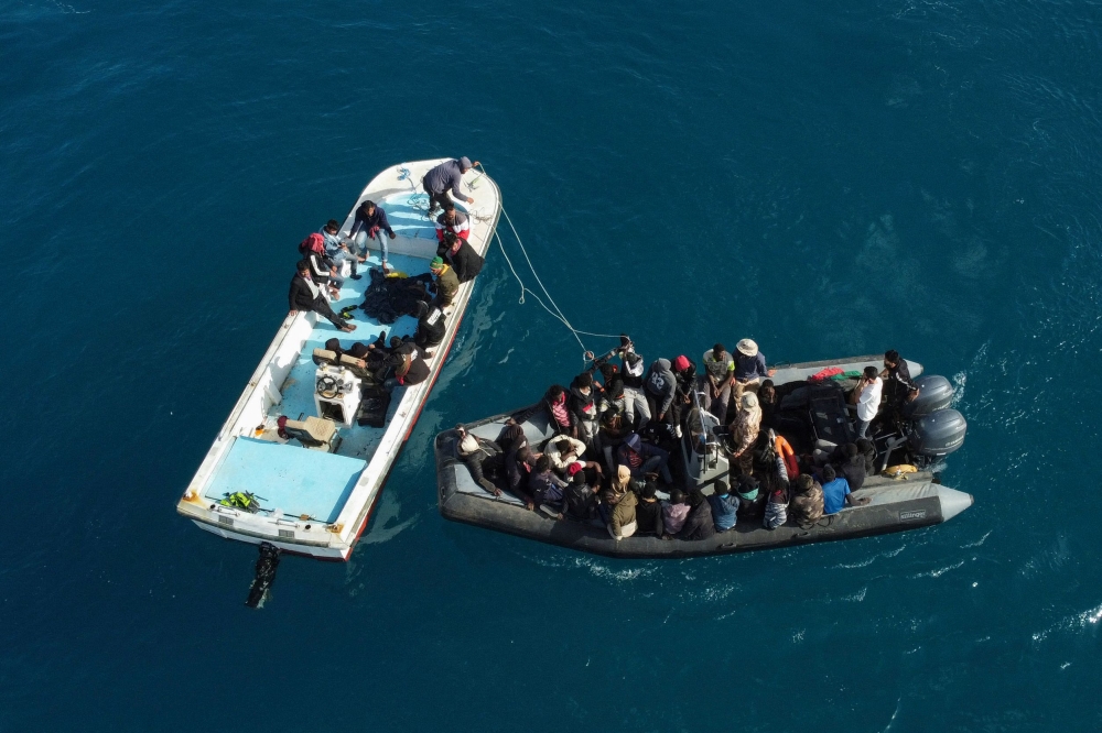 An aerial picture shows boats transporting migrants of different nationalities entering a port in the Garabulli area following their rescue at sea by the Libyan Coast Guard, on April 25, 2023. (Photo by Mahmud Turkia / AFP)