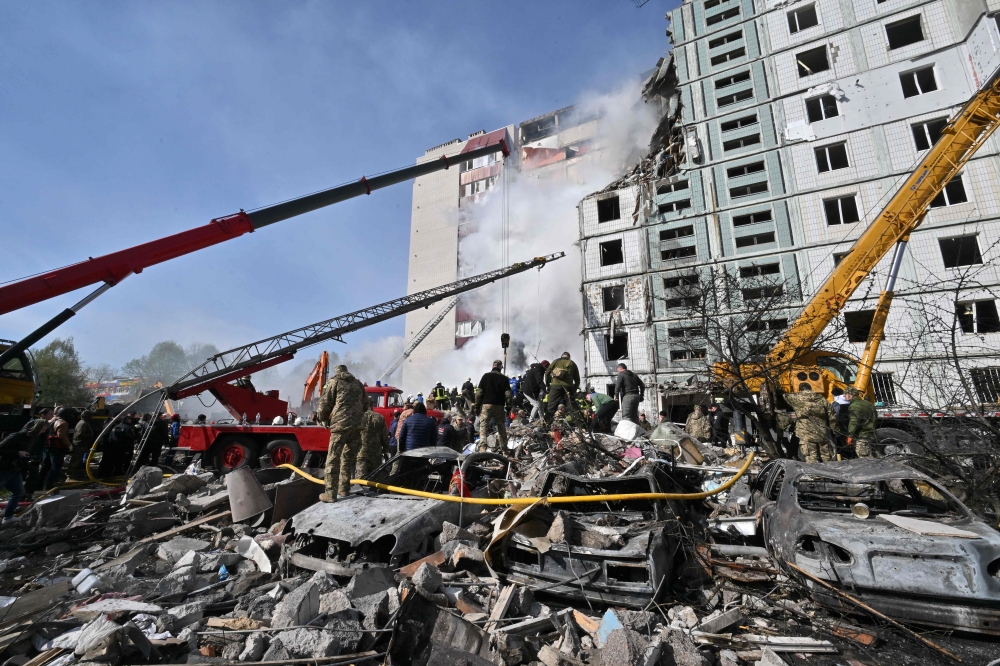Rescuers work in the rubble of a damaged residential building in Uman, south of Kyiv on April 28, 2023, after Russian missile strikes targeted several Ukrainian cities overnight. Photo by Sergei SUPINSKY / AFP