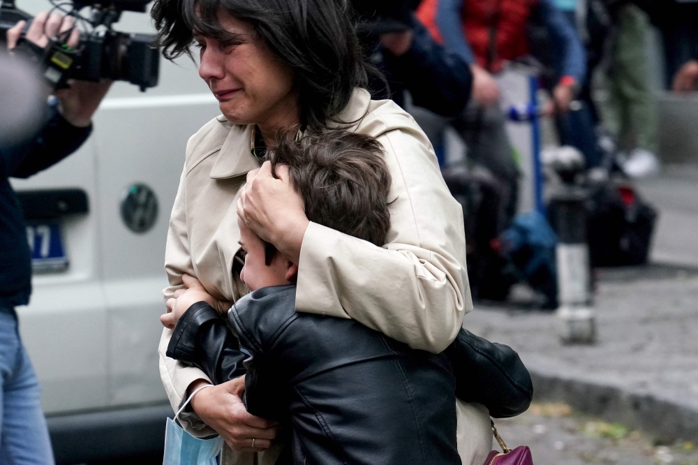 A parent escorts her child following a shooting at a school in the capital Belgrade on May 3, 2023.  (Photo by Oliver Bunic / AFP)
