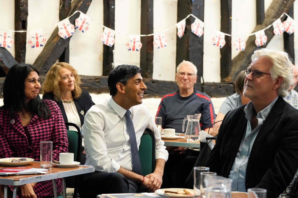 Britain's Prime Minister Rishi Sunak (C) and Britain's Home Secretary Suella Braverman (L) visit a U3A community group at the Chiltern leisure centre in Amersham, England, on May 3, 2023. (Photo by Frank Augstein / POOL / AFP)