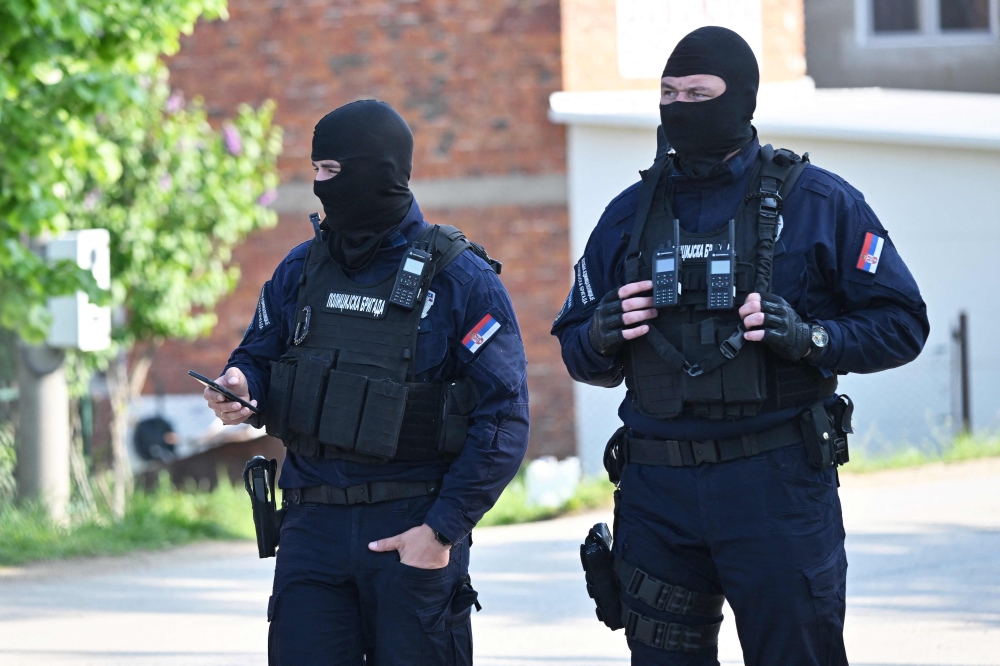 Masked policemen secure an area in the village of Dubona near the town of Mladenovac, about 60 kilometres (37 miles) south of Serbia's capital Belgrade, on May 5, 2023, in the aftermath of a drive-by shooting. Photo by ANDREJ ISAKOVIC / AFP