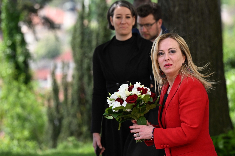 Italy's Prime Minister Giorgia Meloni holds a bouquet of flowers as she arrives to meet her Czech counterpart on May 10, 2023 in Prague, Czech Republic. (Photo by Michal Cizek / AFP)