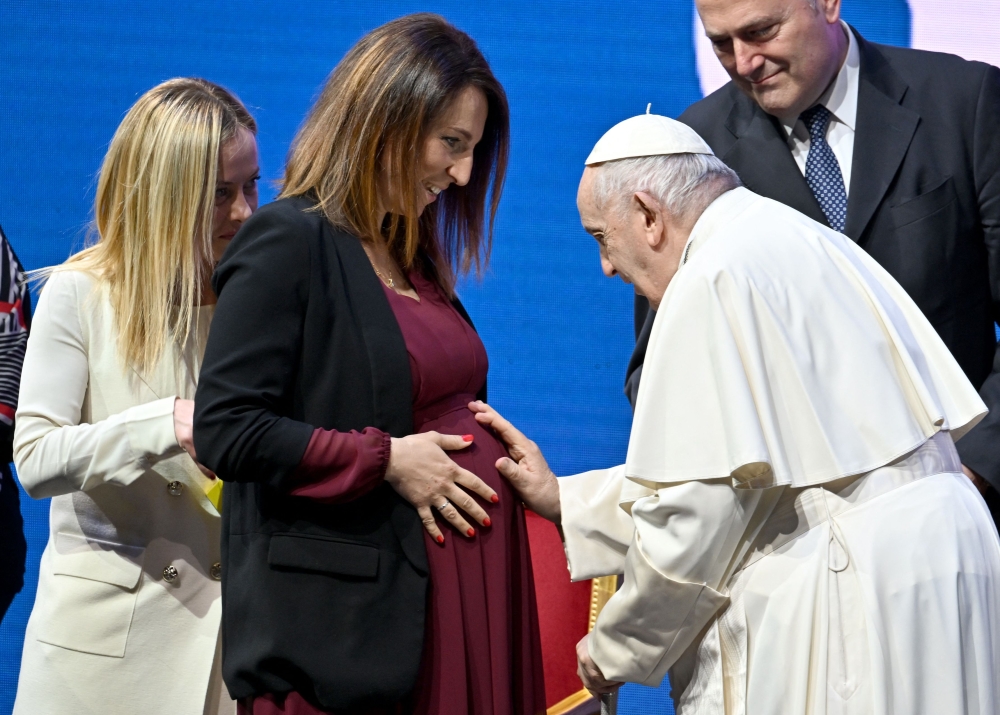 Pope Francis blesses a pregnant woman at the end of a conference in Rome on May 12, 2023 during a two-day 'General States of Birth' conference. (Photo by Filippo Monteforte / AFP)