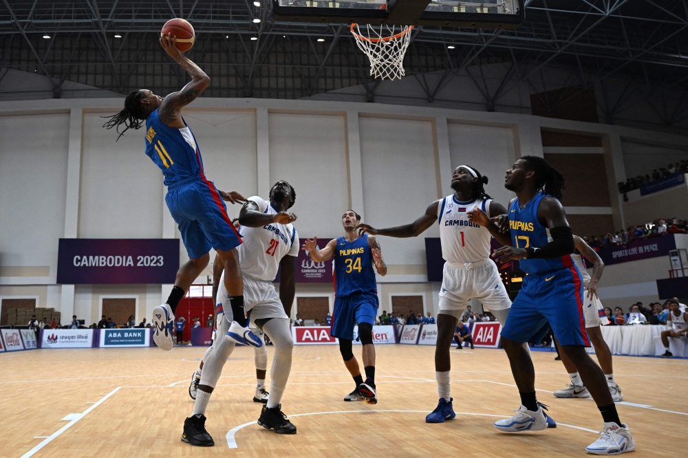 Philippines' Christopher Elijah Duque Newsome (L) shoots the ball during the men's basketball final against Cambodia at the 32nd Southeast Asian Games (SEA Games) in Phnom Penh on May 16, 2023. (Photo by Mohm Rasfan / AFP)