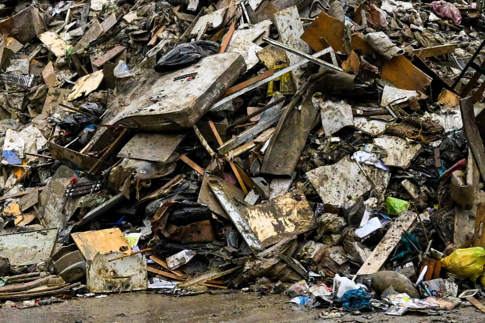 A pile of waste of mattresses, clothes and furniture coming from flooded homes is pictured on May 19, 2023 in Faenza, after floodwaters hit the Emilia-Romagna region. (Photo by Andreas Solaro / AFP)
