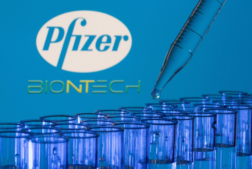 File Photo: Test tubes are seen in front of displayed Pfizer and Biontech logos in this illustration taken, May 21, 2021.(REUTERS/Dado Ruvic)