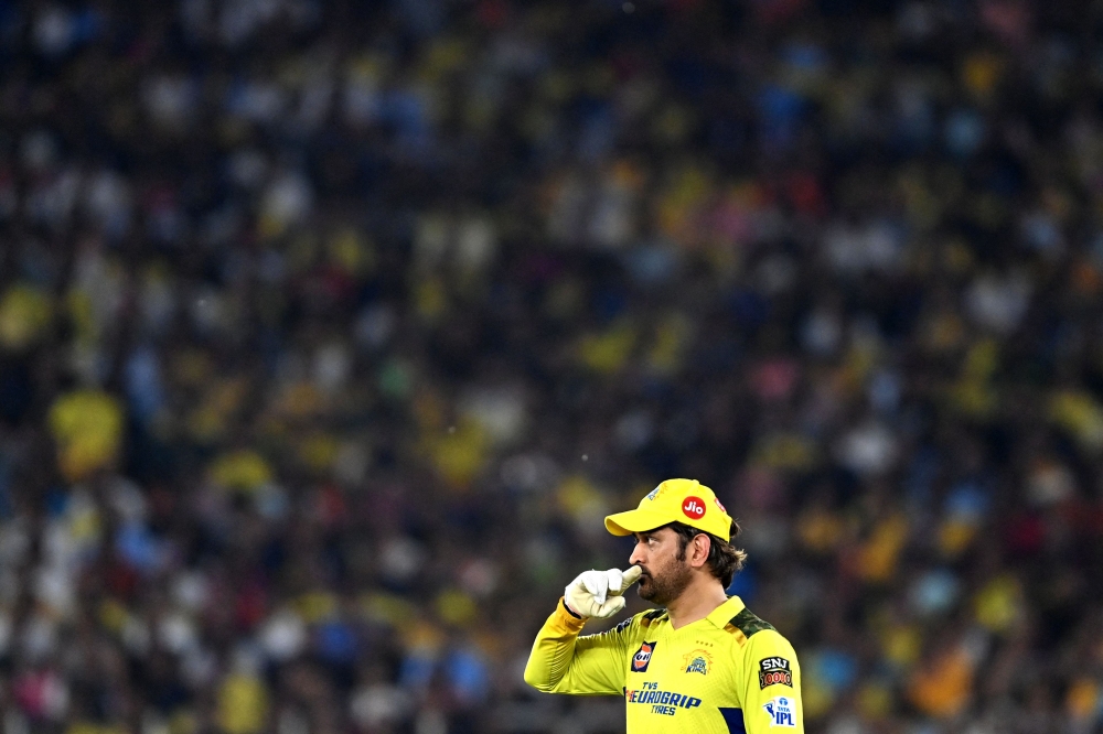 Chennai Super Kings' captain Mahendra Singh Dhoni adjusts the field during the Indian Premier League (IPL) Twenty20 final cricket match between Gujarat Titans and Chennai Super Kings at the Narendra Modi Stadium in Ahmedabad on May 29, 2023. (Photo by Sajjad Hussain / AFP)