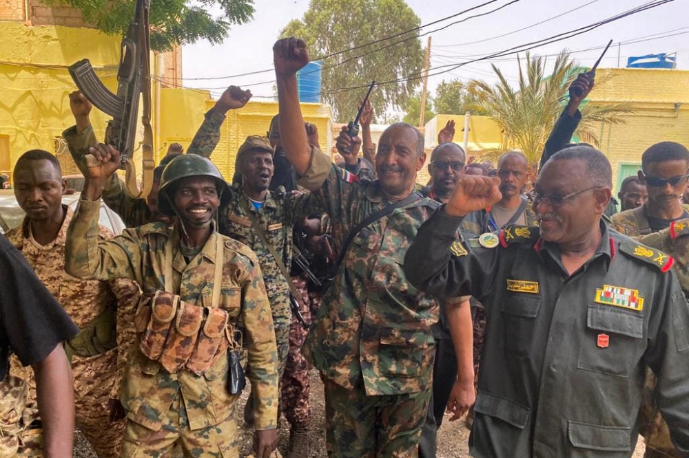 This picture released on the Sudanese Army's Facebook page on May 30, 2023, shows army chief Abdel Fattah al-Burhan (2nd right) cheering with soldiers as he visits some of their positions in Khartoum. (Photo by Sudan's Armed Forces Facebook page / AFP)