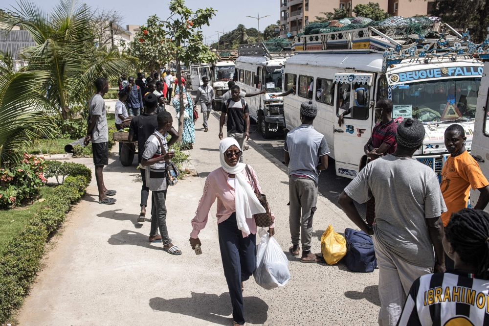 Students carry their luggage as they leave the Cheikh Anta Diop University in Dakar, on June 2, 2023 after being closed due to the violent protests that broke out on University grounds. (Photo by John Wessels / AFP)