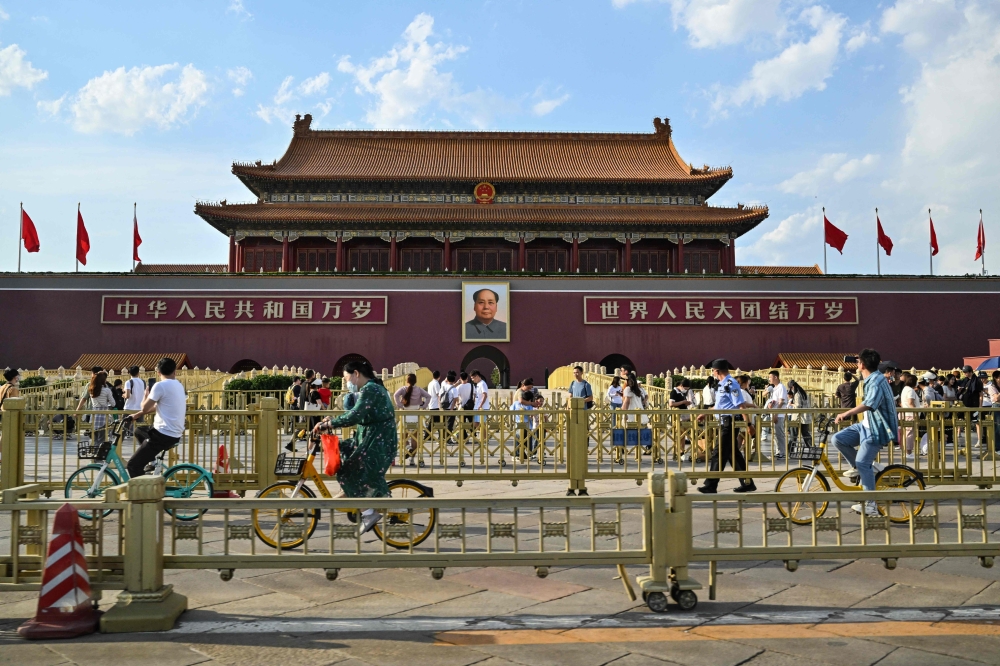 People are seen next to the Tiananmen Gate in Beijing on June 3, 2023, a day before the anniversary of the 1989 Tiananmen crackdown. (Photo by Hector RETAMAL / AFP)