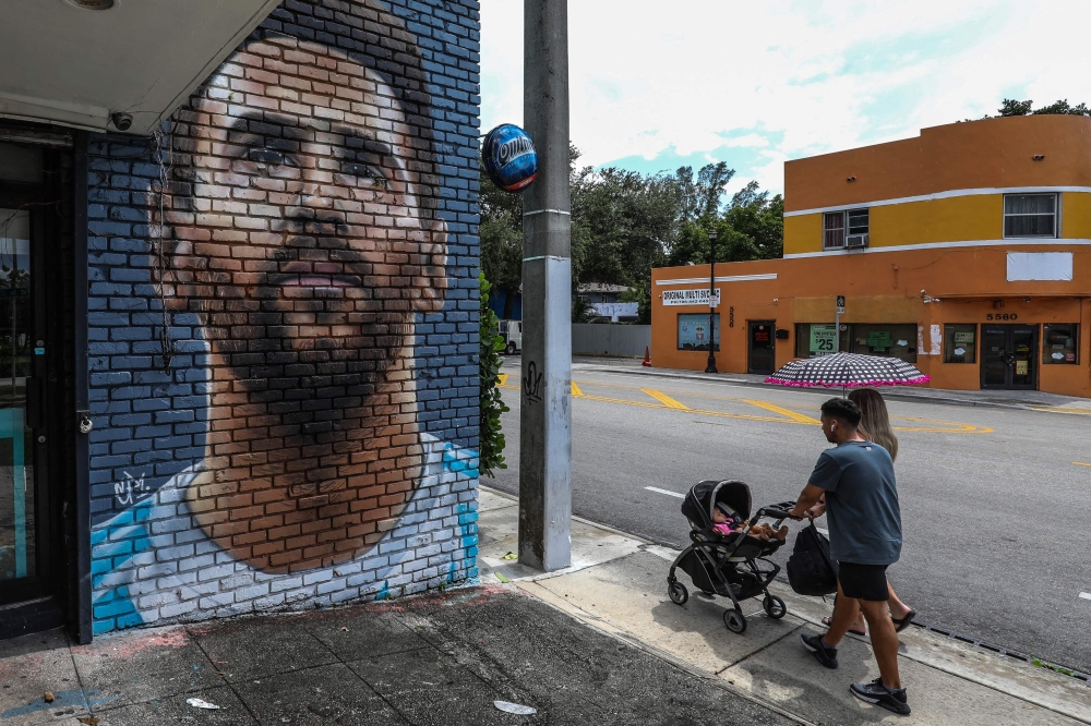 People walk in front of a mural depicting Argentine football player Lionel Messi in Miami on June 7, 2023. (Photo by Giorgio Viera / AFP)