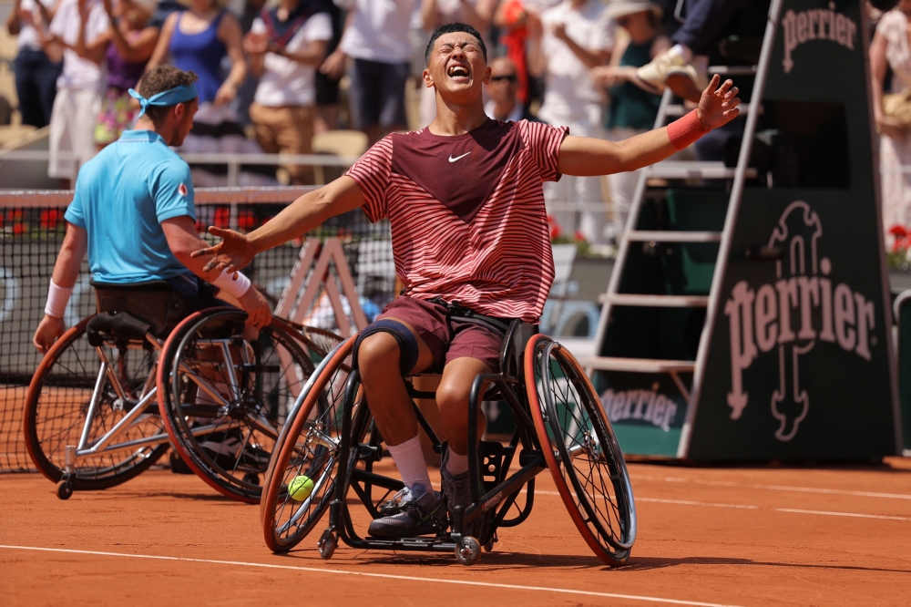 Japan's Tokito Oda (C) celebrates after winning against Britain's Alfie Hewett during their men's wheelchair singles final match on day fourteen of the Roland-Garros Open tennis tournament at the Court Philippe-Chatrier in Paris on June 10, 2023. (Photo by Thomas SAMSON / AFP)