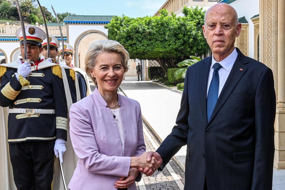 This handout picture provided by the Tunisian Presidency Press Service shows Tunisia's President Kais Saied (right) shaking hands with European Commission President Ursula von der Leyen at Carthage Palace in Carthage on the eastern outskirts of the Tunisian capital on June 11, 2023. (Photo by Tunisian Presidency / AFP) 