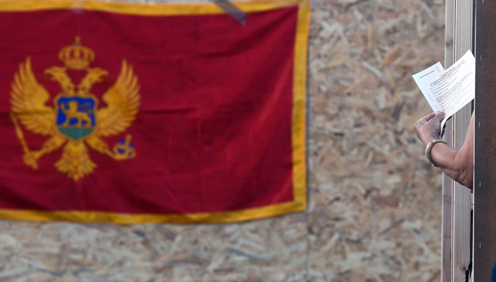 A citizen of Montenegro holds a document at a voting station in Podgorica, on June 11, 2023. (Photo by SAVO PRELEVIC / AFP)