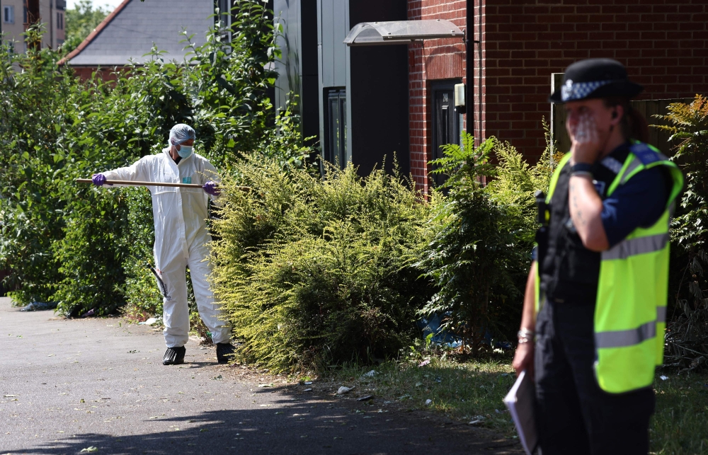 A police forensics officer conducts a search on Ilkeston Road in Nottingham, central England (Photo by Darren Staples / AFP)
