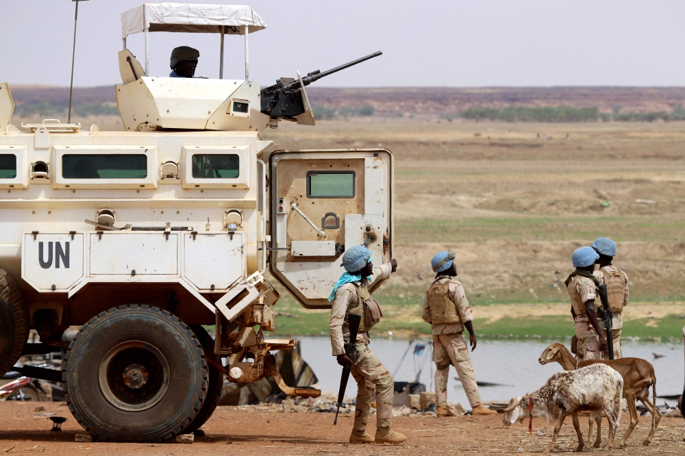 (FILES) Senegalese soldiers the UN peacekeeping mission in Mali MINUSMA (United Nations Multidimensional Integrated Stabilisation Mission in Mali) dismount an armoured personnel carrier, patrolling in the streets of Gao, on July 24, 2019. (Photo by Souleymane Ag Anara / AFP)

