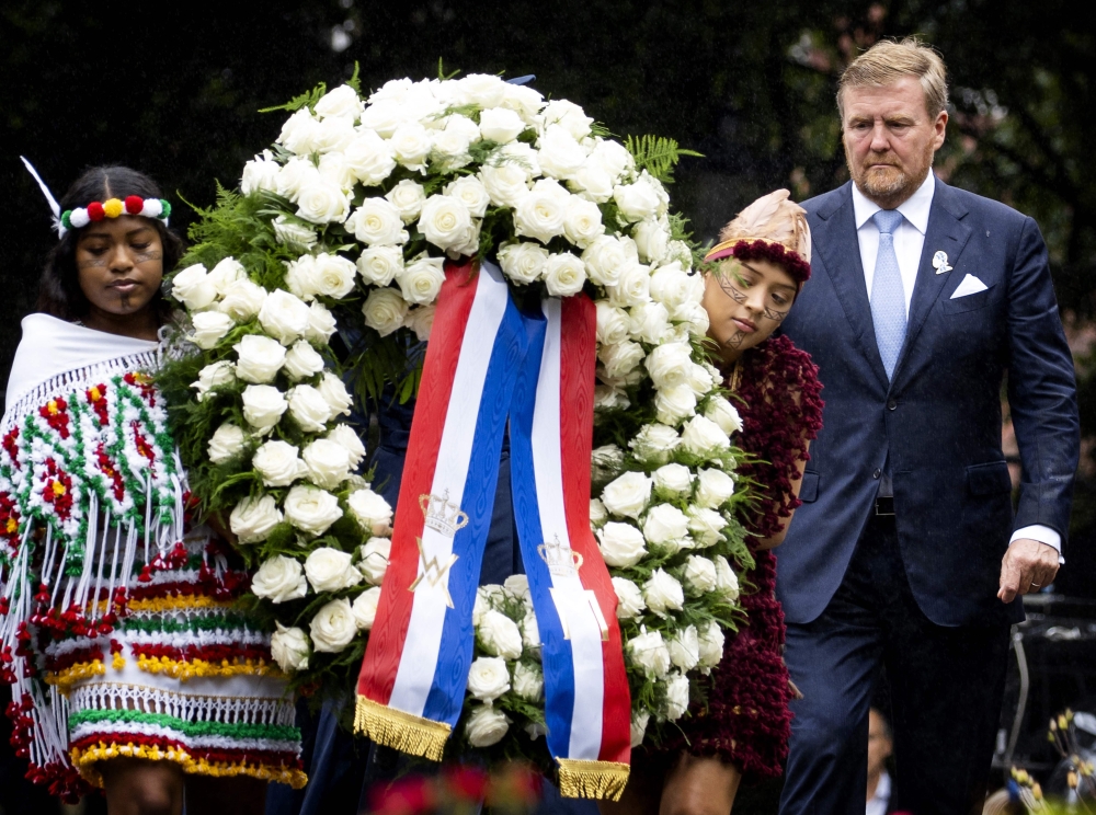 Netherlands' King Willem-Alexander (right) lays a wreath during the National Remembrance Day of Slavery in The Oosterpark, Amsterdam on July 1, 2023. (Photo by Remko de Waal / ANP / AFP)