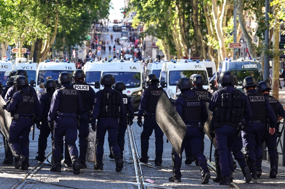 Police officers walk as they try to disperse protesters with tear gas during a demonstration against police in Marseille, southern France on July 1, 2023. (Photo by CLEMENT MAHOUDEAU / AFP)