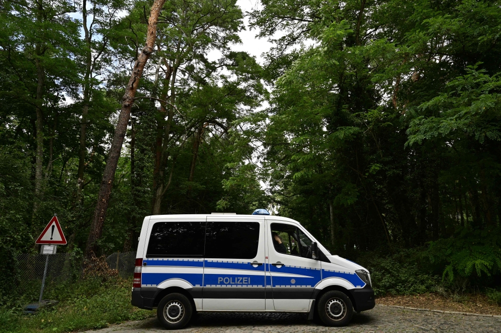 A police vehicle blocks a forest path during the search in the area for a wild animal on the loose, reportedly a lioness, on July 20, 2023 in Kleinmachnow, south-west of Berlin. Photo by John MACDOUGALL / AFP