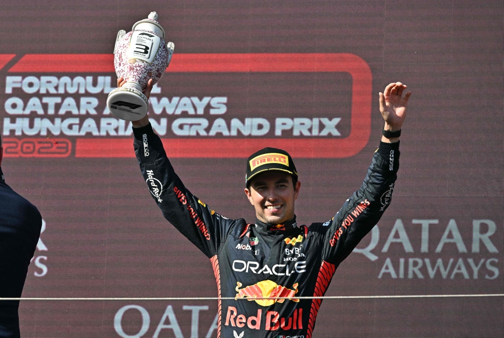 Third placed Red Bull Racing's Mexican driver Sergio Perez lifts his trophy on the podium after the Formula One Hungarian Grand Prix at the Hungaroring race track in Mogyorod near Budapest on July 23, 2023. Photo by ATTILA KISBENEDEK / AFP