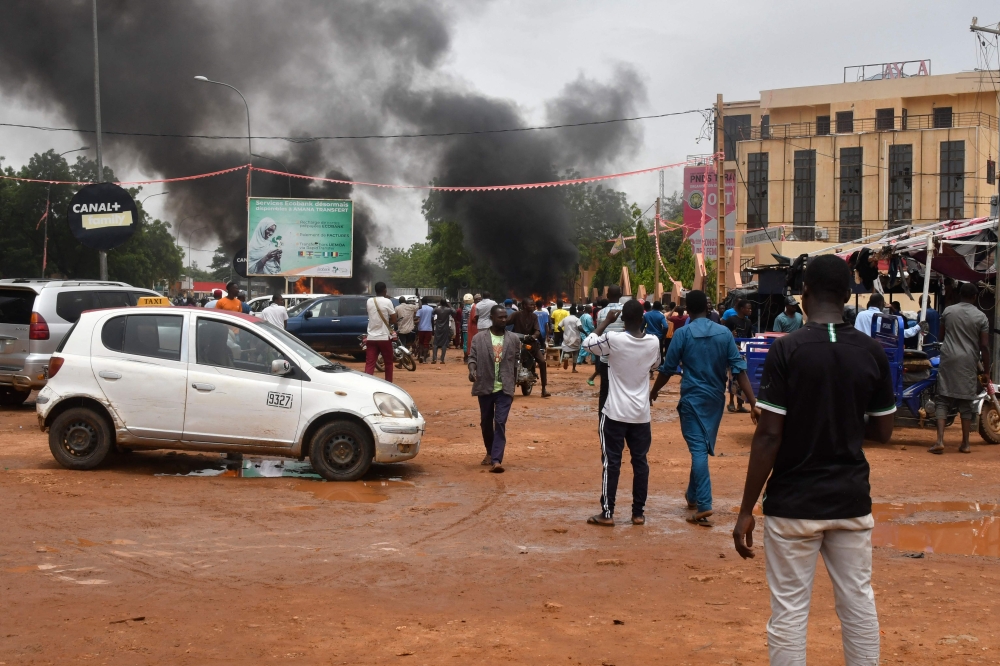 A general view of billowing smoke as supporters of the Nigerien defence and security forces attack the headquarters of the Nigerien Party for Democracy and Socialism (PNDS), the party of overthrown President Mohamed Bazoum, in Niamey on July 27, 2023. (Photo by AFP)
