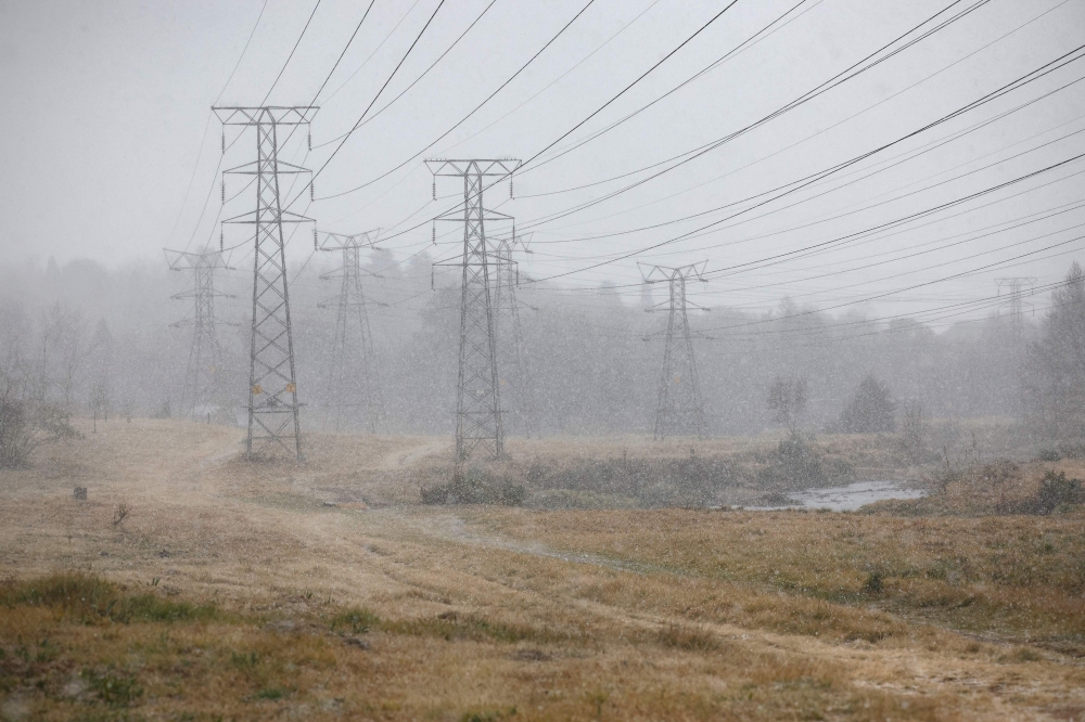 This photograph shows a general view of the Delta park in Johannesburg as snow falls, on July 10, 2023. (Photo by Wikus de Wet / AFP)