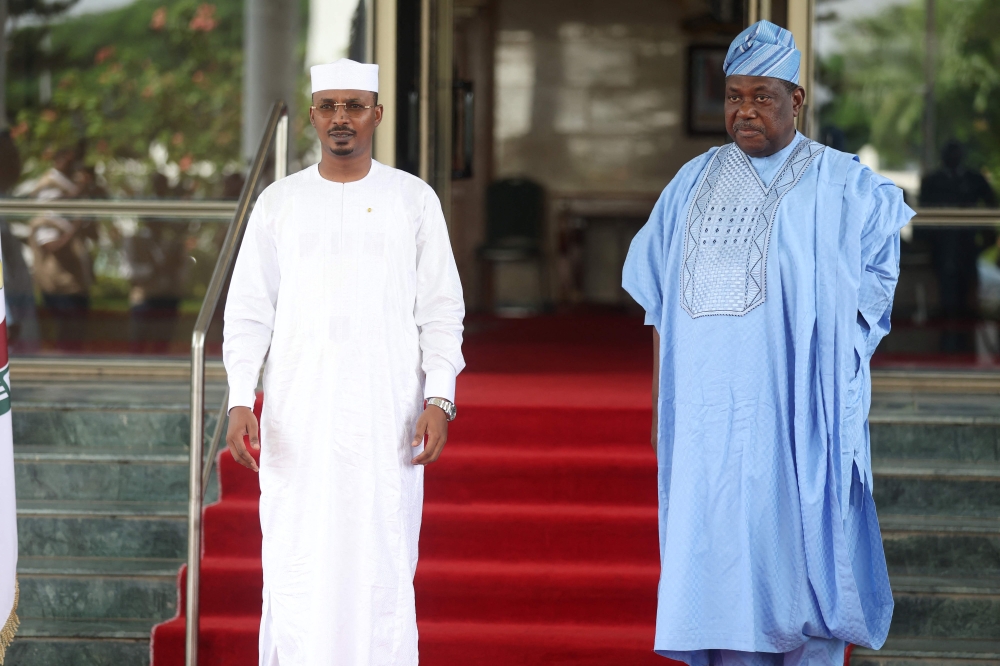 Chad President, Mahamat Deby (L) is received by Nigeria's Secretary of the Government of the Federation, George Akume, during the Economic Community of West African States (ECOWAS) head of states and government extraordinary session, in Abuja on July 30, 2023. (Photo by Kola SULAIMON / AFP)
