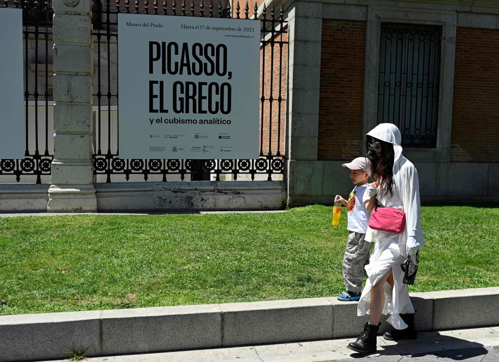 Tourists walk outside the Museo Del Prado in Madrid, on August 6, 2023 as the country is bracing for the third heatwave of the summer. (Photo by Oscar Del Pozo / AFP)