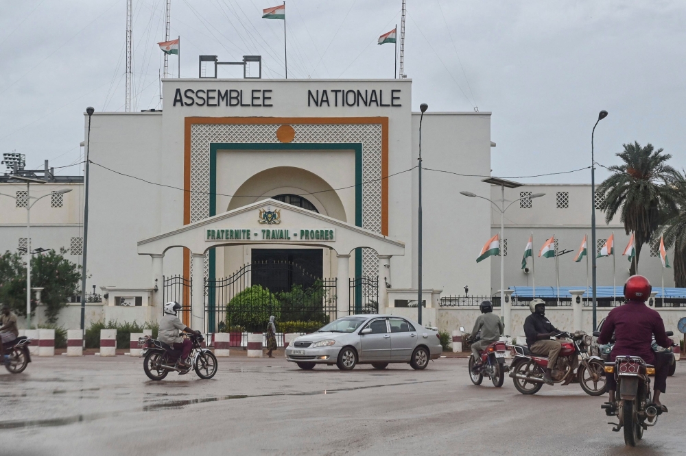 Motorists drive past the National Assembly in Niamey on August 7, 2023. (Photo by AFP)