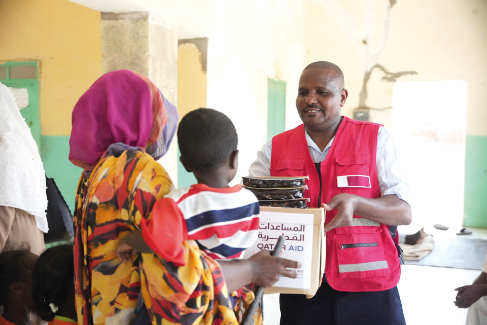 A QRCS official distributes hygiene kits to one of the beneficiaries of the humanitarian response.