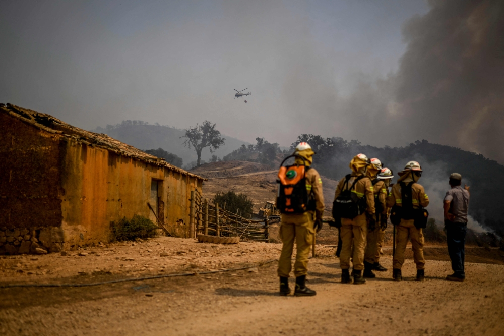 Personnel of the Protection and Relief Intervention Group (GIPS) specialised in combating forest fires, arrive to battle a wildfire in Reguengo, Portalegre district, south of Portugal, on August 8, 2023. (Photo by Patricia De Melo Moreira / AFP)