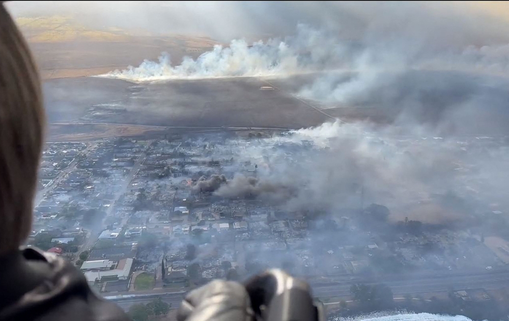 This handout video grab courtesy of Richard Olsten taken on August 9, 2023 shows smoke billowing from destroyed buildings as wildfires burn across Maui, Hawaii. Photo by Richard Olsten / AFP