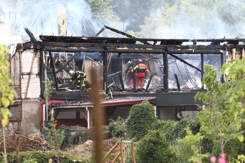 Firefighters inspect a burnt building after a fire erupted at a holiday home for disabled people in Wintzenheim, eastern France, on August 9, 2023. Photo by Sebastien BOZON / AFP