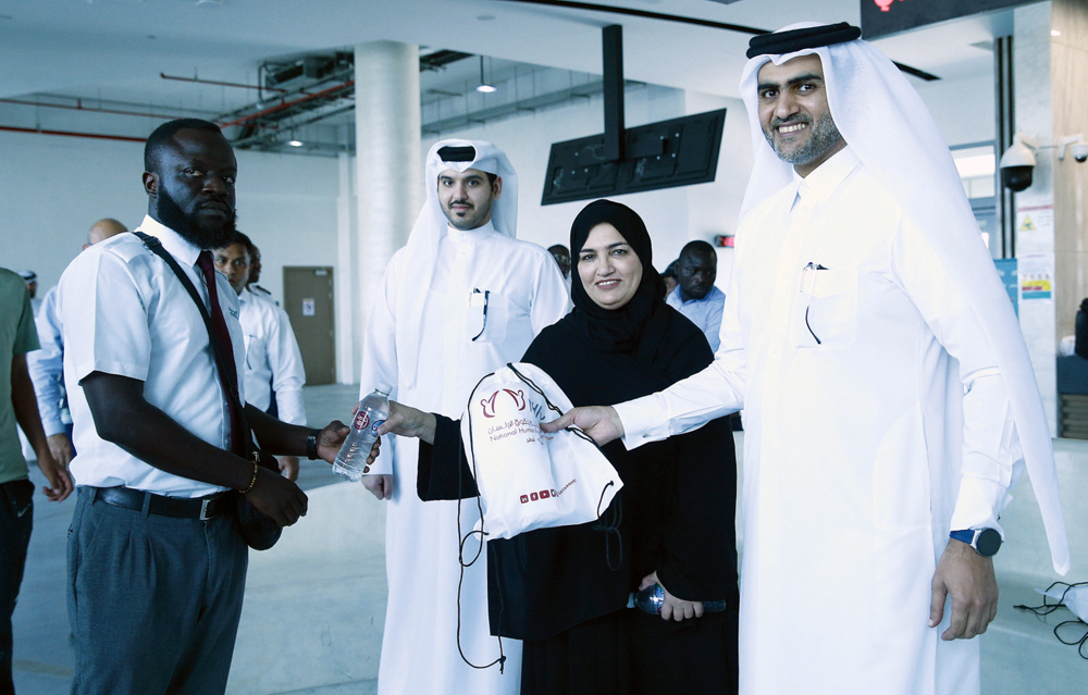 Al Abdulghani Motors representatives and officials distributing water bottles and heat stress awareness materials among drivers and workers.  