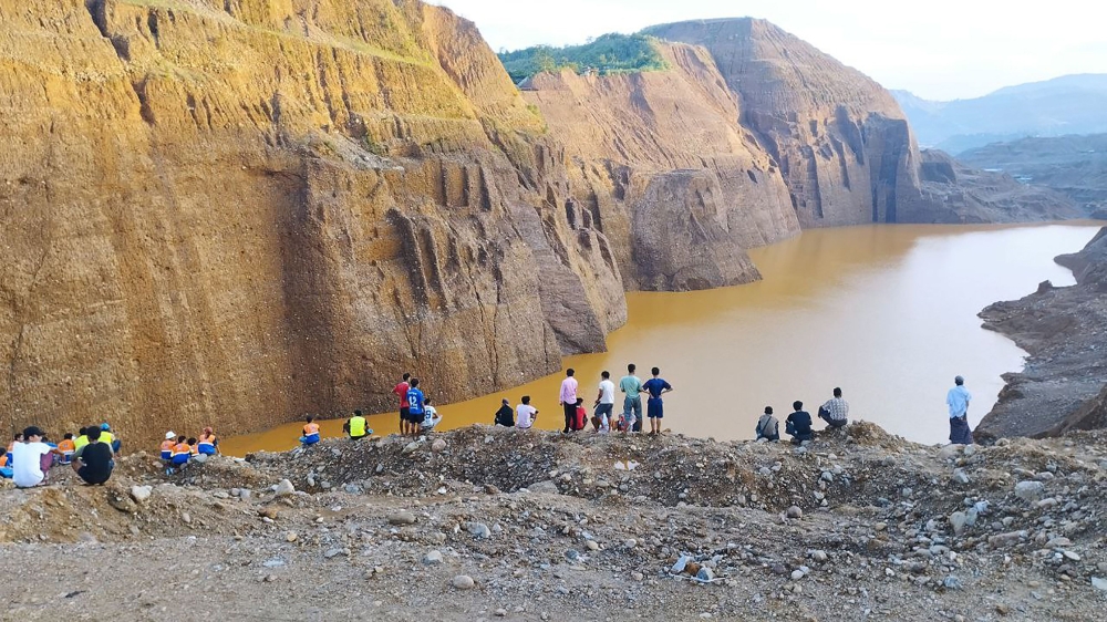 This photo taken on August 13, 2023 and received courtesy of Tarlin Mg via Facebook on August 14 shows people looking at the site of a deadly landslide at an unregulated jade mine near northern Kachin's Hpakant township. (Photo by Tarlin MG / UGC / AFP) 