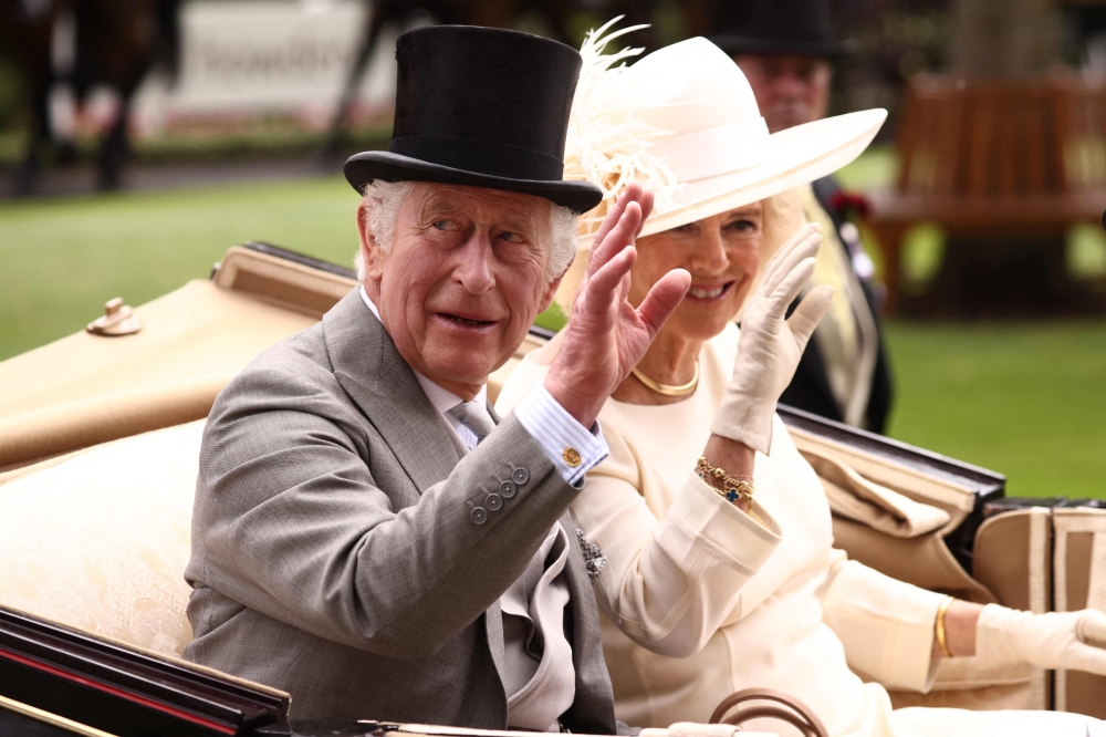 Britain's King Charles III (L) and Britain's Queen Camilla (R) arrive in the parade ring in a horse-drawn carriage in Ascot, west of London, on June 24, 2023. (Photo by Henry Nicholls / AFP)