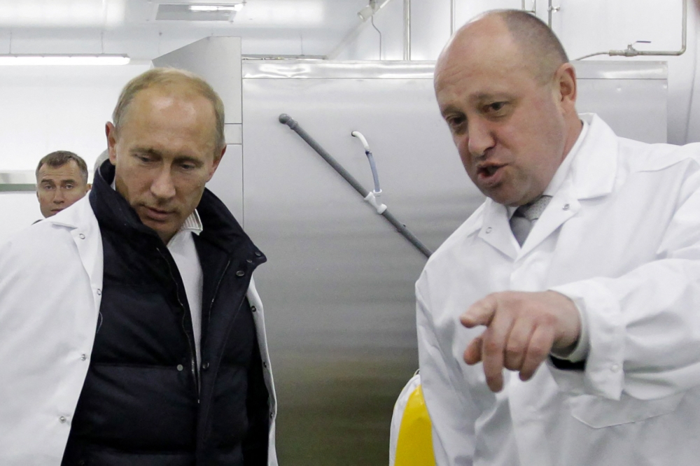 File photo: Businessman Yevgeny Prigozhin (right) points as he shows Russian Prime Minister Vladimir Putin his school lunch factory outside Saint Petersburg on September 20, 2010. (Photo by Alexey Druzhinin / SPUTNIK / AFP)