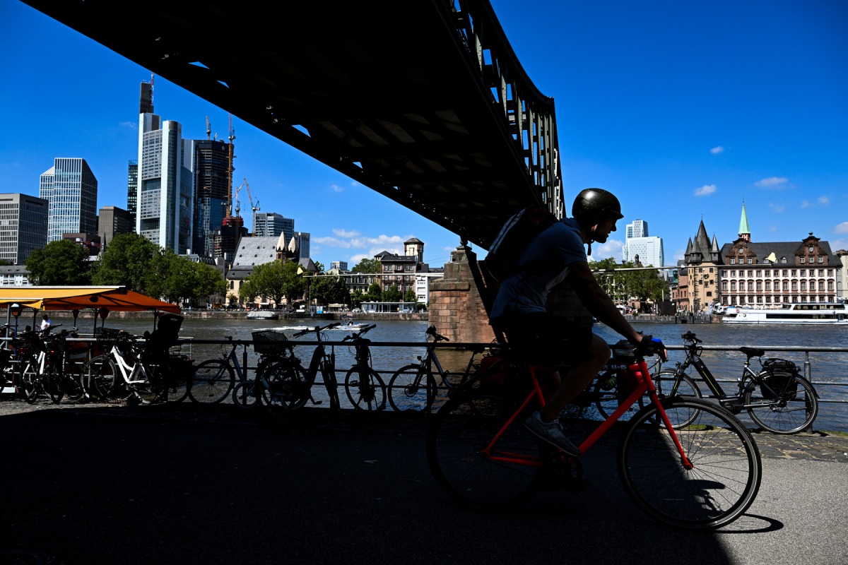 A man ride bicycle along the Main river embankment during a sunny day in Frankfurt am Main, western Germany, on August 10, 2023. Photo by Kirill KUDRYAVTSEV / AFP

