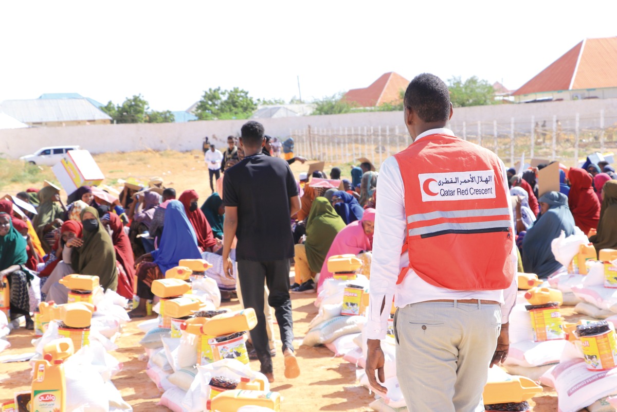 QRCS and KRCS volunteers distributing food aid among internally displaced people in Somalia.