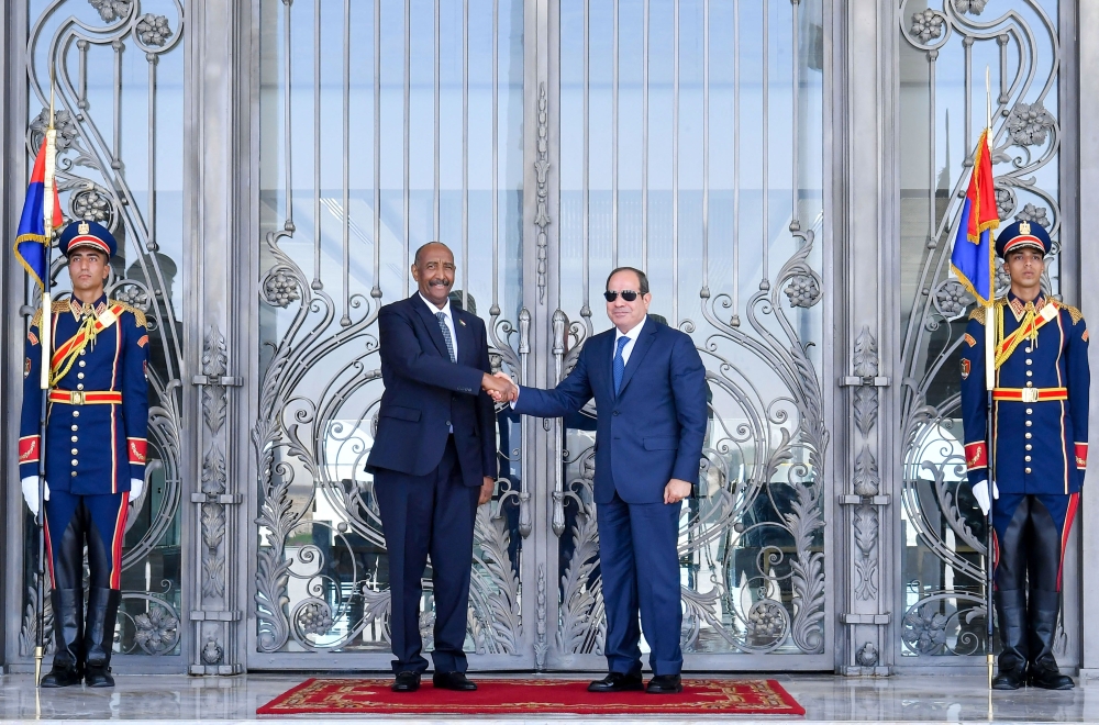 A handout picture released by the Egyptian Presidency shows Egyptian President Abdel Fattah al-Sisi (right) receiving the President of Sudan's Transitional Sovereignty Council (TSC) General Abdel Fattah al-Burhan in El Alamein on Egypt's northern coast on August 29, 2023. (Photo by Egyptian Presidency / AFP)