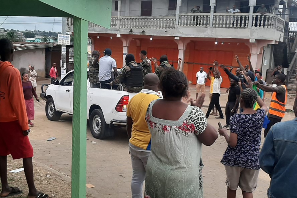 Residents applaud members of the security forces in the Plein Ciel district Libreville on August 30, 2023. (Photo by AFP)