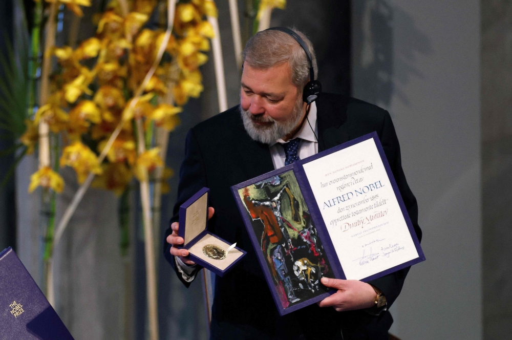 Nobel Peace Prize laureate Dmitry Muratov of Russia poses with the Nobel Peace Prize diploma and medal during the gala award ceremony for the Nobel Peace prize on December 10, 2021 in Oslo. (Photo by Odd ANDERSEN / AFP)
