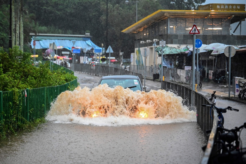 A motorist drives through floodwaters on Lantau Island in Hong Kong on September 8, 2023. Photo by Peter PARKS / AFP